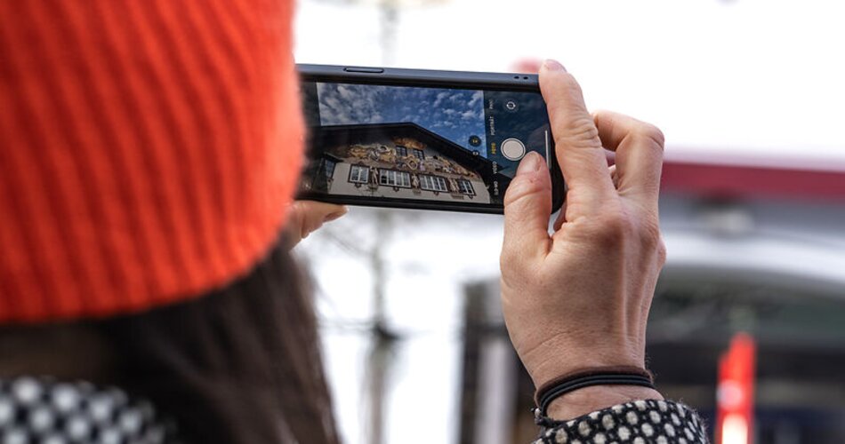 Ortsführung durch Garmisch | © GaPa Tourismus GmbH/ Roadtrip the World Blick durch ein Smartphone auf Lüftlmalereien bei einer Ortsführung durch Garmisch | © GaPa Tourismus GmbH/ Roadtrip the World