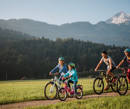 Blick auf eine Familie bei einer Fahrradtour durch Garmisch-Partenkirchen | © Zugspitz Arena Bayern Tirol/ Thomas Marzusch