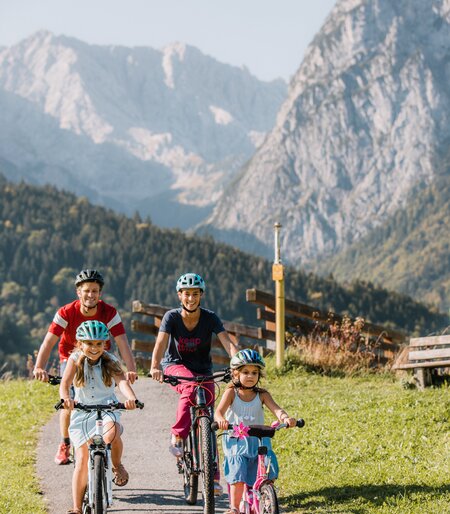 Familie bei einer Fahrradtour mit Blick auf das Wettersteingebirge | © Zugspitz Arena Bayern Tirol/ Thomas Marzusch