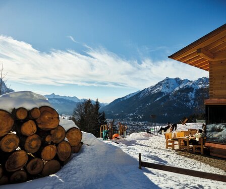 Blick auf die Tannenhütte im Winter mit Bergen im Hintergrund | © GaPa Tourismus GmbH/Christian Stadler