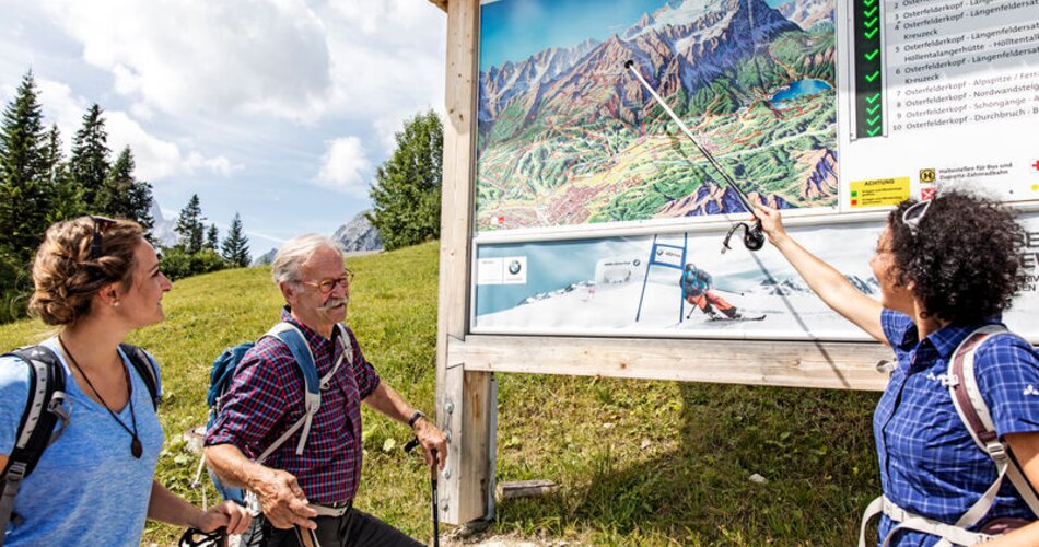 Gruppe zeigt auf Wanderkarte | © Markt Garmisch-Partenkirchen/Christian Stadler