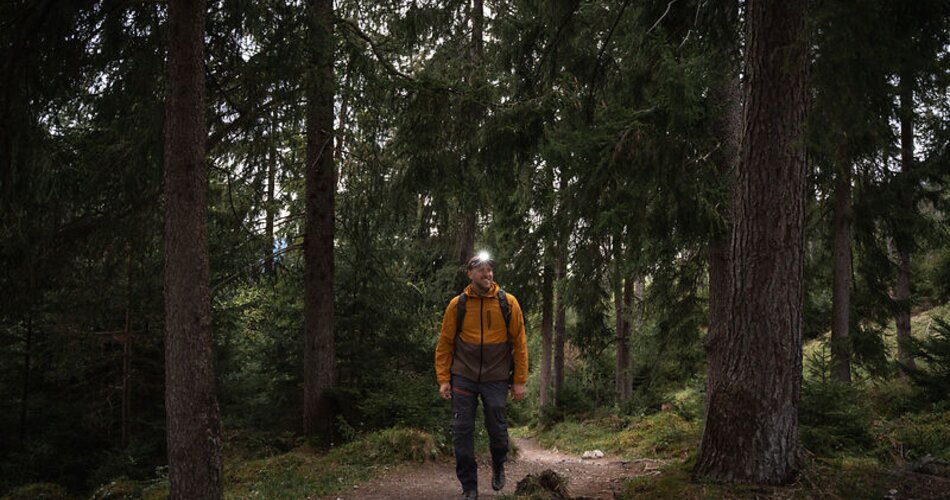 Blick auf einen Bergsteiger mit Stirnlampe im Wald in Garmisch-Partenkirchen | © GaPa Tourismus GmbH/ Roadtrip the World